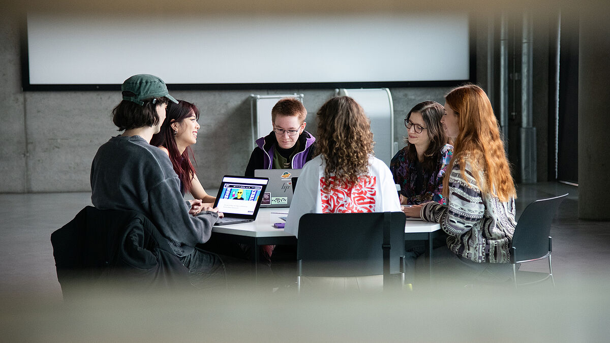 Ein studentisches Team sitzt zusammen an einem runden Tisch