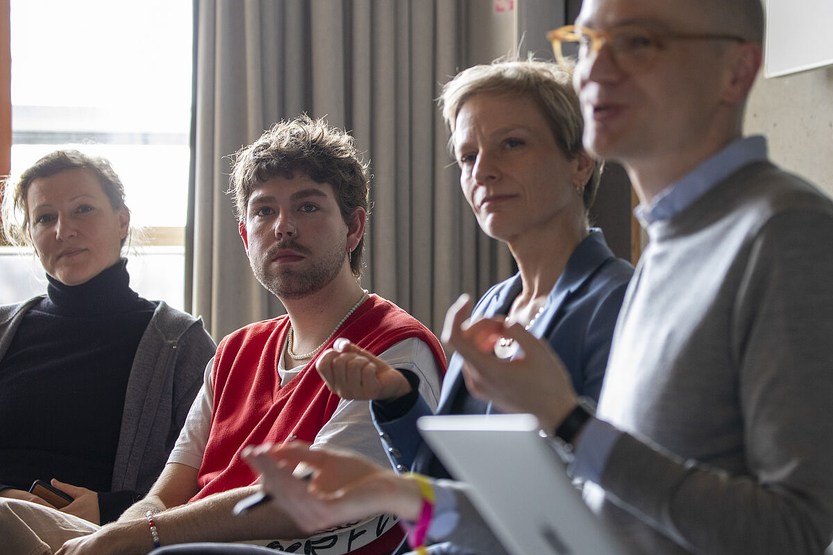 Lehrende und Teilnehmende des Workshops "Queere Sichtbarkeit" führen eine angeregte Unterhaltung.