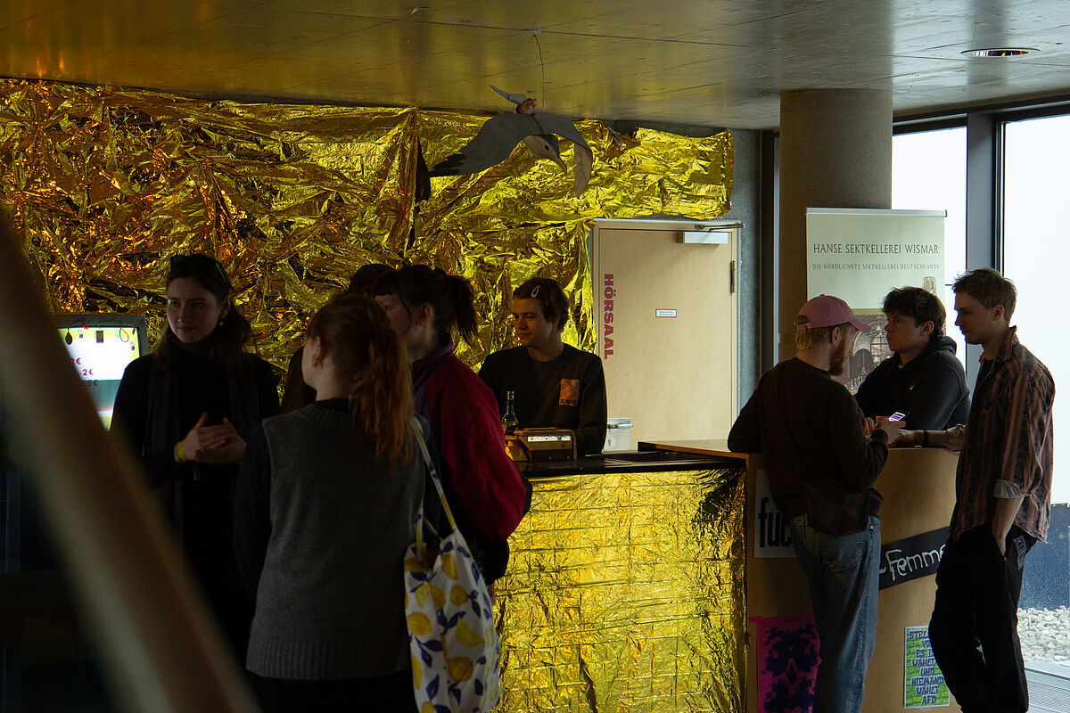 Menschen stehen vor der Bar und unterhalten sich – das Bild entstand während des Netzwerkabends des Festivals.