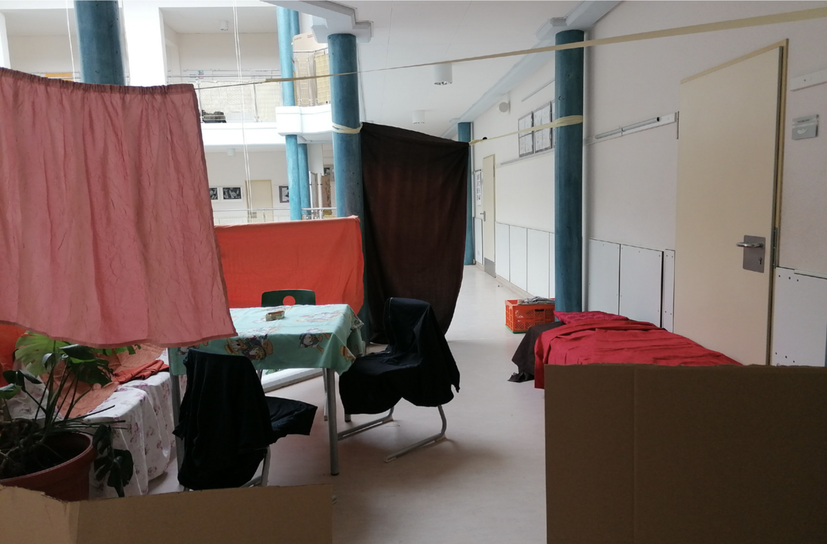 Ein Tuch hängt über einer Wäschleine, ein Tisch, Stühle.