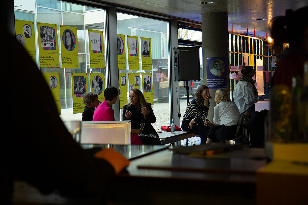 Mehrere Teilnehmende unterhalten sich in entspannter Atmosphäre beim Netzwerkabend des Festivals.