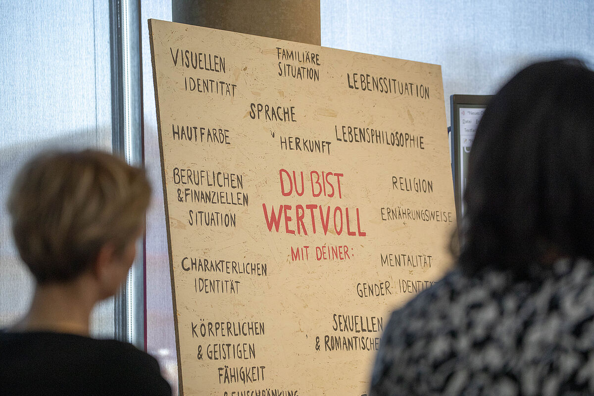 Eine handgeschriebene Tafel mit der Aufschrift „Du bist wertvoll mit deiner...“ steht während des Festivals gut sichtbar platziert.