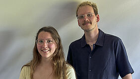 Folge 20 Es sind die beiden Personen vor einer hellen Rückwand zu sehen.