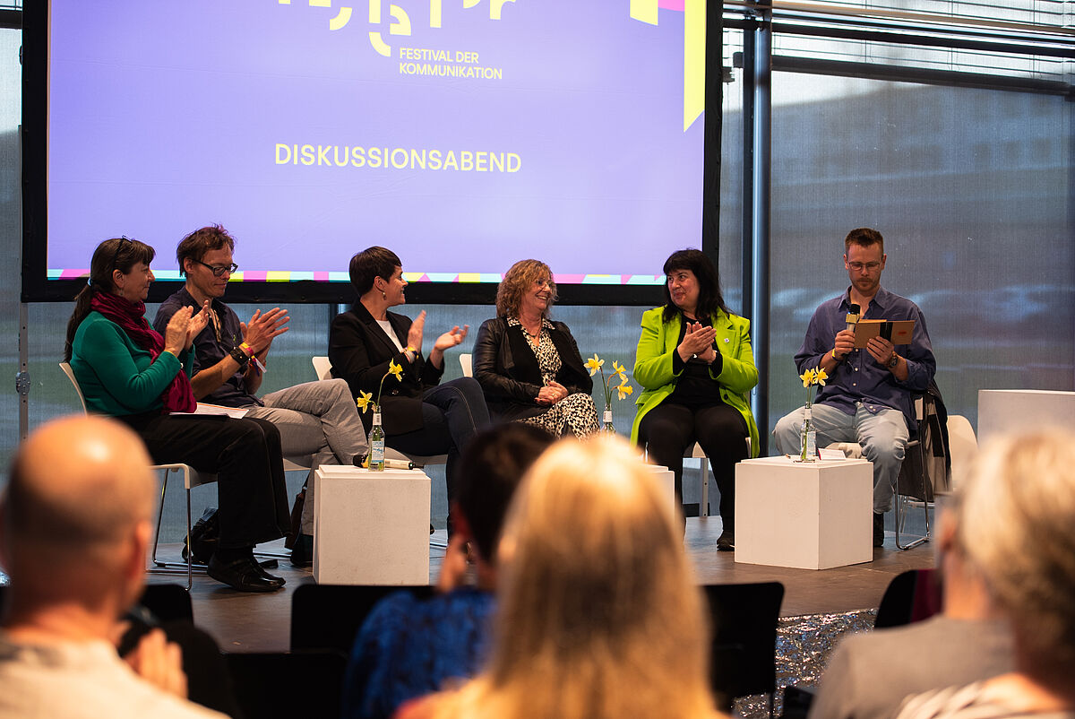 Mehrere Gäste nehmen an der Podiumsdiskussion teil und sprechen auf der Bühne über die aktuellen Herausforderungen der Inklusion und Vielfalt in der Zivilgesellschaft.