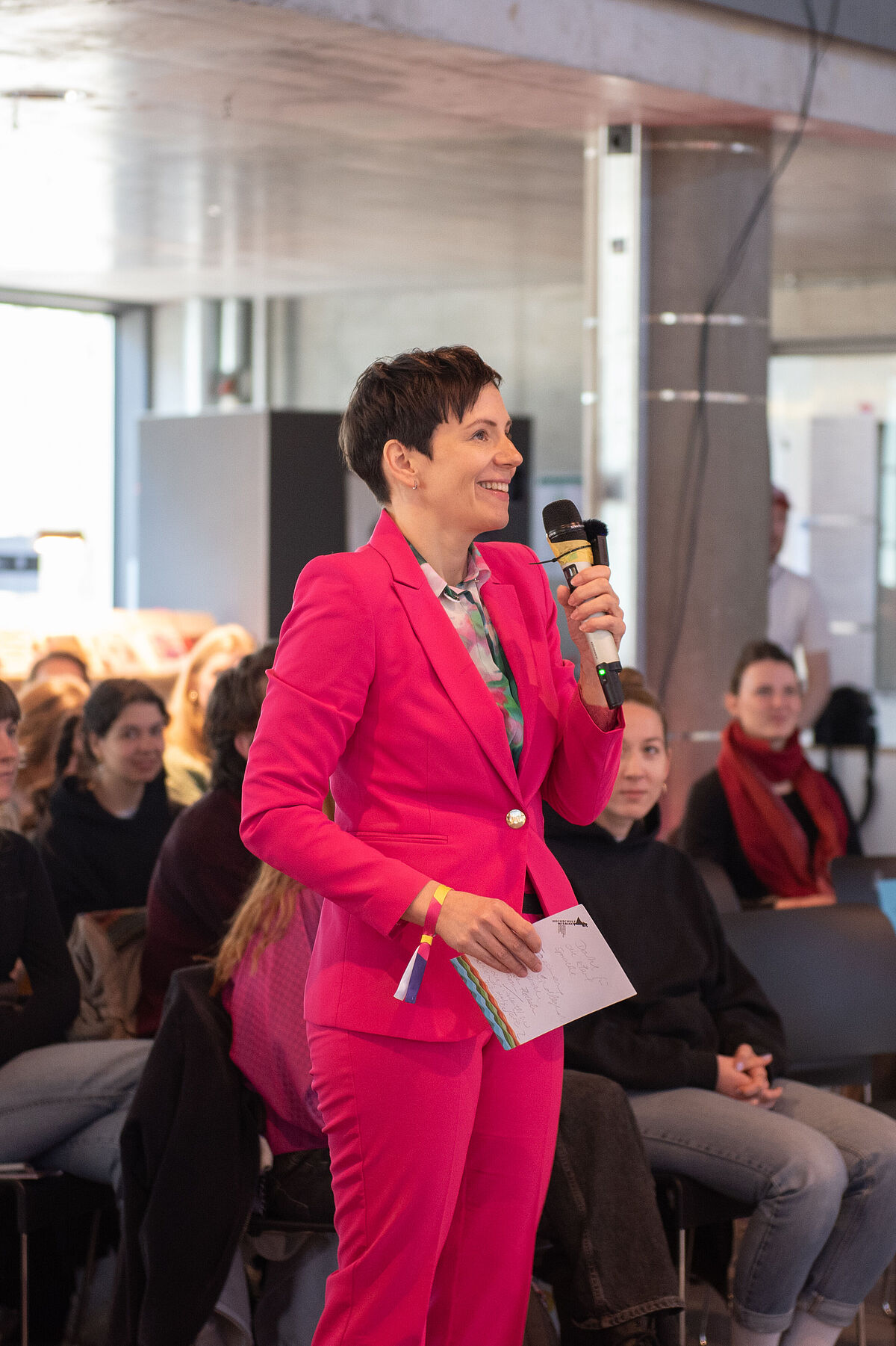 Eine Person steht am Mikrofon und stellt Raul Krauthausen eine Frage.