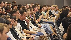 Theatersaal Wir schauen von der Seite in eine Publikumsreihe hinein.