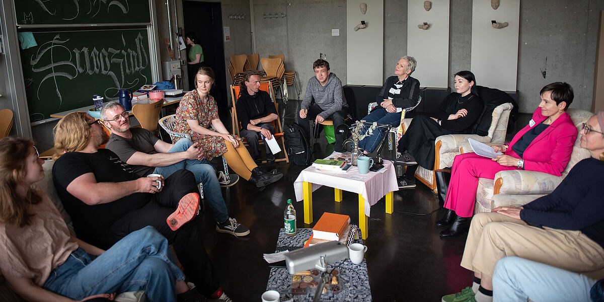 Eine Gruppe Menschen sitzt in einem Kreis zusammen