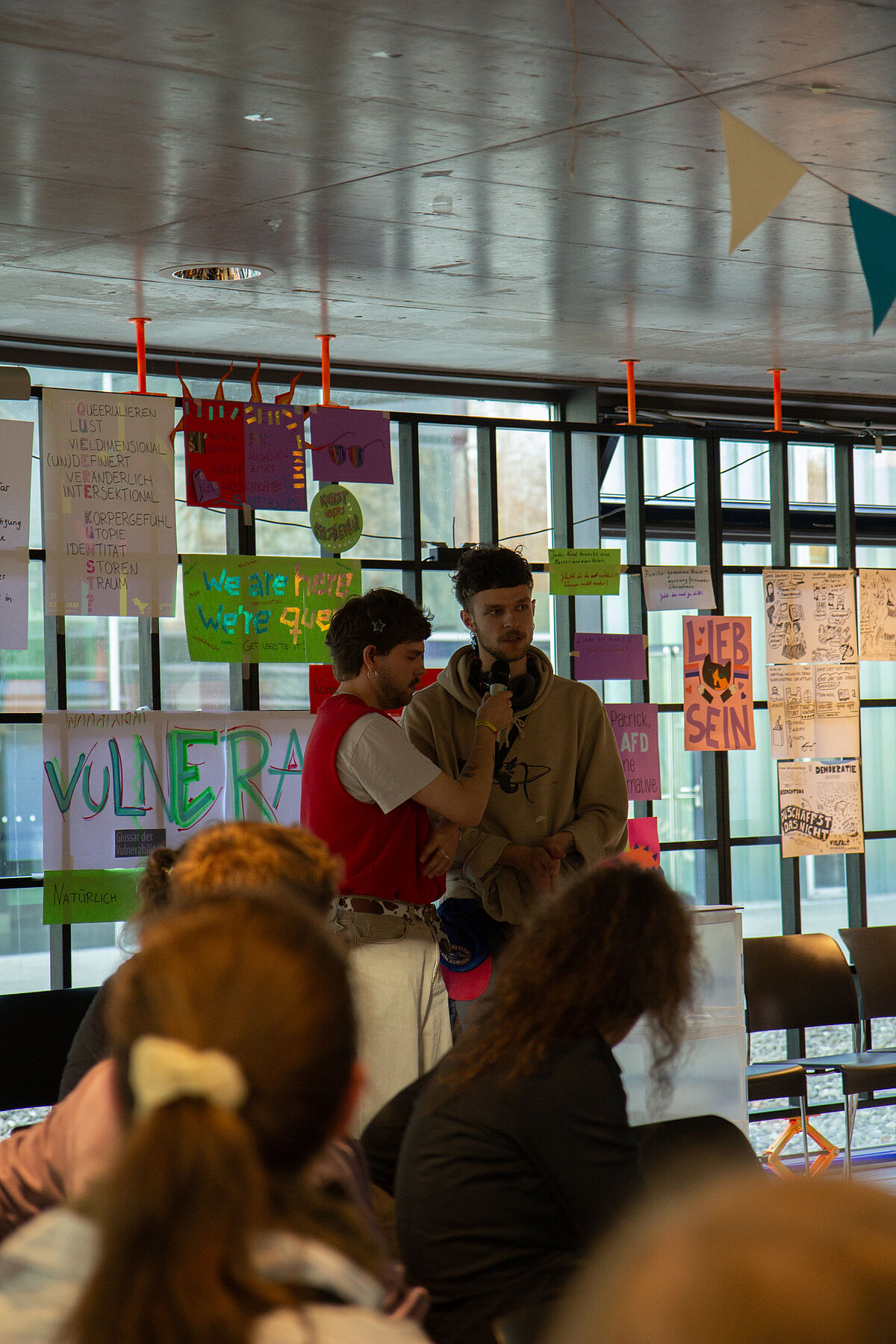 Zwei Teilnehmende präsentieren ihre Workshop-Ergebnisse während der Postersession, in der die Arbeiten des Tages ausgestellt werden.