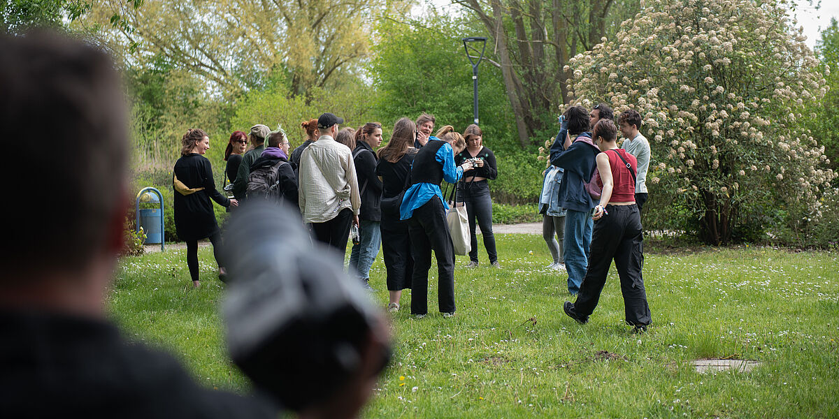 Eine Gruppe Menschen steht in der Natur und fotografiert