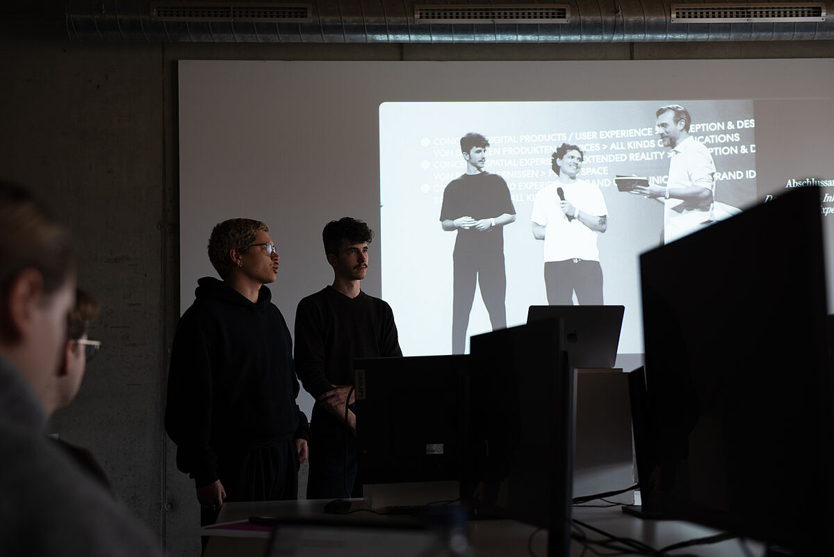 Etienne Wagner und Dominik Krüger während ihres Workshops zum Thema Inklusives Corporate Design – sie sprechen vor den Teilnehmenden.