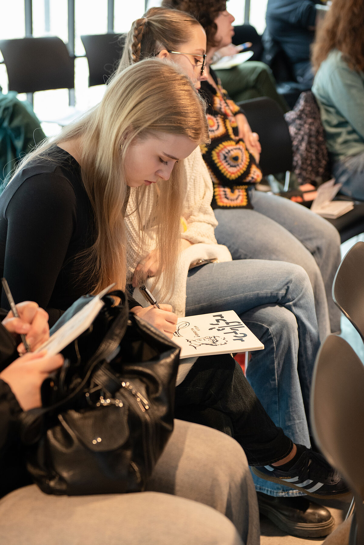 Eine Teilnehmerin skizziert während eines Vortrags, um die besprochenen Themen visuell darzustellen.