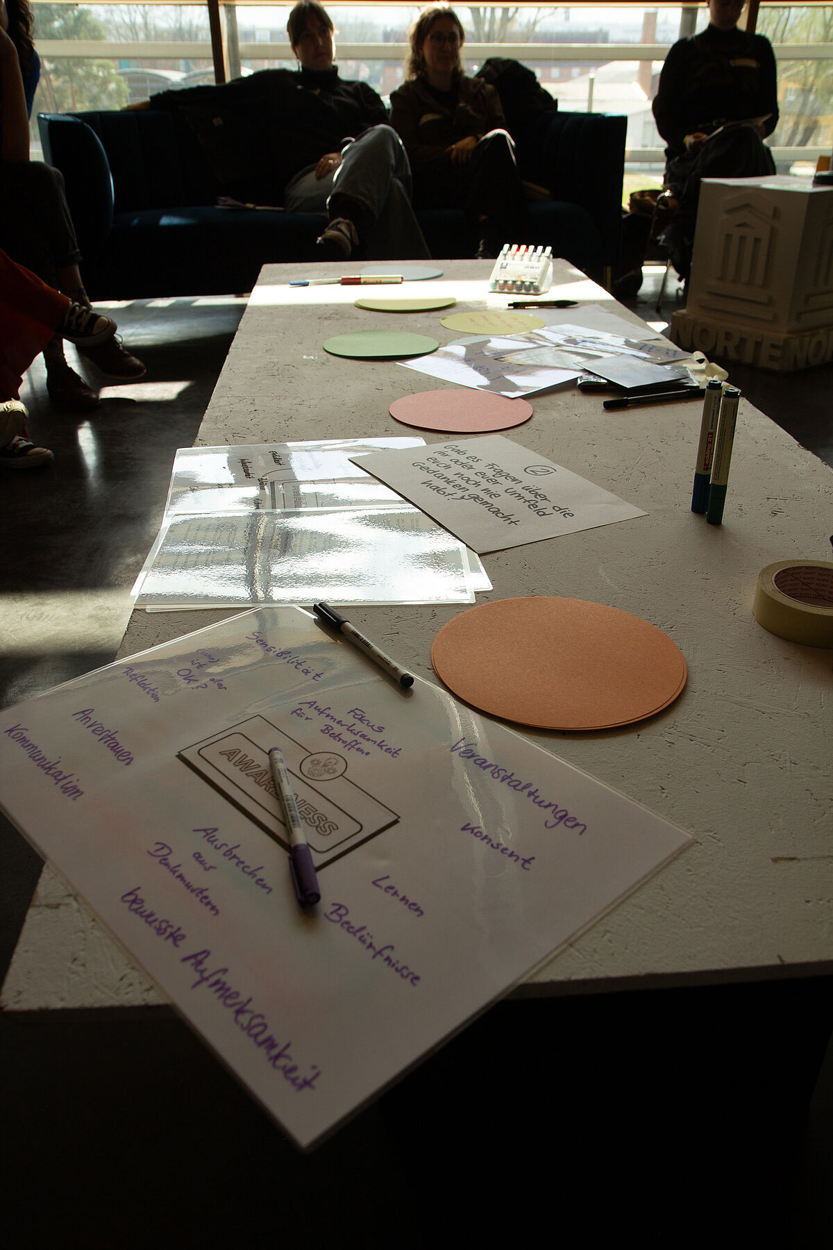 Auf einem Tisch liegen selbstgeschriebene Zettel, die die Arbeitsergebnisse der Teilnehmenden im Workshop "Awareness im Alltag" zeigen.